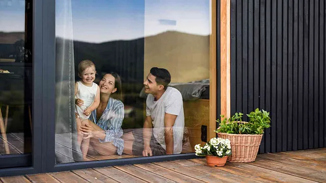 Kosten Hausbau Junge Familie mit kleiner Tochter drinnen, Wochenende im Containerhaus auf dem Land.