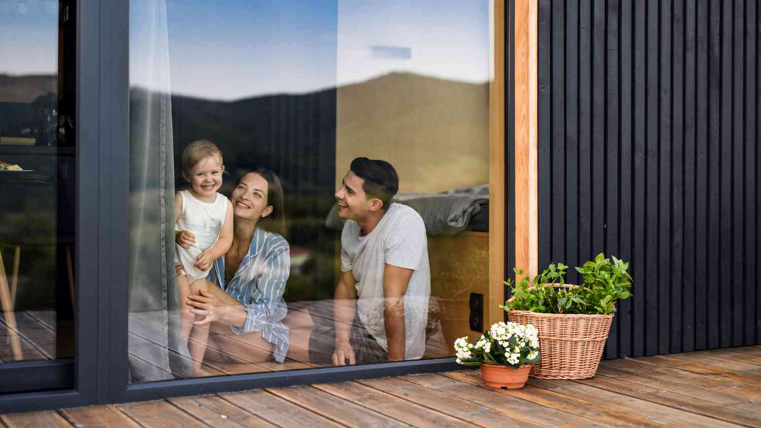 Junge Familie mit kleiner Tochter drinnen, Wochenende im Containerhaus auf dem Land.